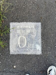 地面の「そすいさんぽ 琵琶湖から0km」の表示