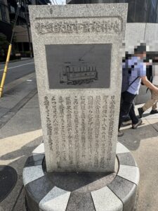 電気鉄道事業発祥地の石碑。明治28年の路面電車の絵