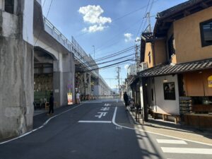 高架の下の道の先にある踏切と疏水の二の橋